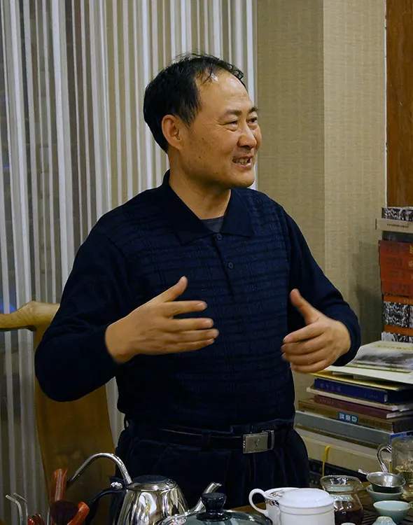 高润祥教授在向两位客人介绍兜底儿网画家及其作品