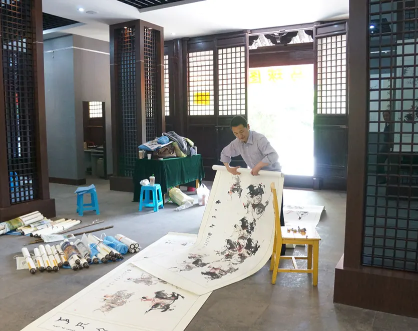 兜底儿网展览部主任、签约书法家子慧黄勇先生在对将要展览的作品进行规划安排