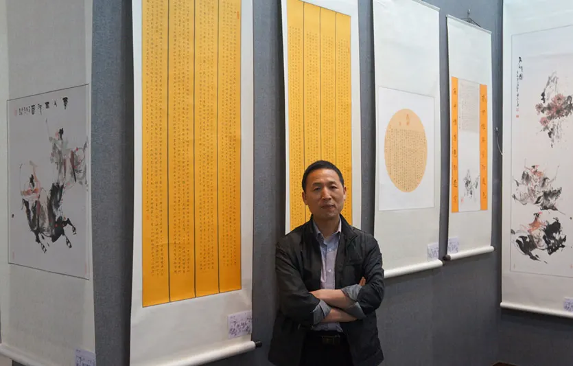 子慧黄勇在他的应邀友情参展的小楷作品前合影留念