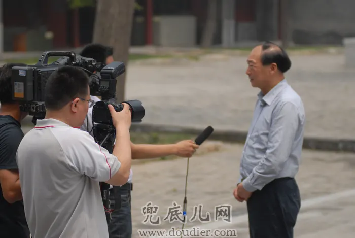记者在采访国务院参事、画家刘坚