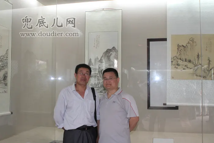 记者与兜底儿网签约画家朱仕明老师合影